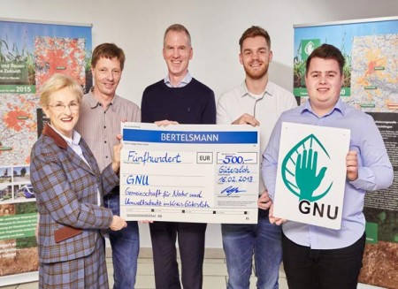 Die Bertelsmann-Auszubildenden Tim Becker und Kevin Viereck (rechts) übergaben kürzlich gemeinsam mit Klaus Röttger, Leiter der Abteilung Zentrale Bildung bei Bertelsmann (Mitte), einen Spendenscheck über 500 Euro an Angelika Daum (Vorsitzende GNU) und Ulrich Zurlinden (Geschäftsstelle GNU). Foto: © Bertelsmann, Fotograf Kai Uwe Oesterhelweg. 