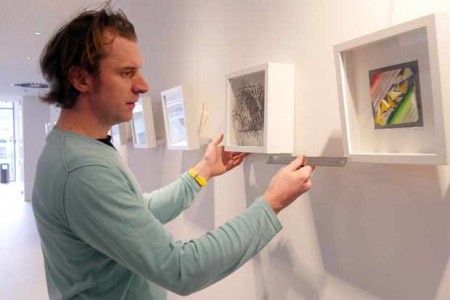 Künstler Joachim Stäbler beim Aufhängen seiner Bilder im Parlamentarischen Bereich des Kreishauses.