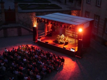 Traumhafter Sommerabend: Die ausgeleuchtete Bühne setzt die Musiker im Dalheimer Ehrenhof passend in Szene. (Foto: LWL/Johanna Pietsch)
