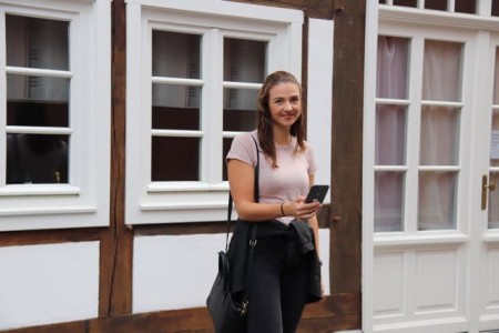 Cassandra Korth testet die Stadtführungs-App an einem der historischen Gebäude am Rande des Doktorplatzes in Rheda. 