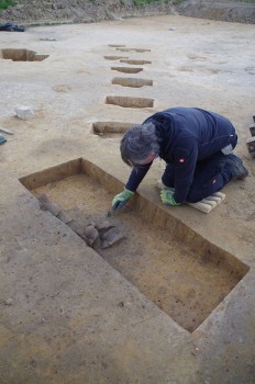Die jungsteinzeitliche Keramik wird vorsichtig freigelegt. Foto: Archäologie am Hellweg eG /Küting