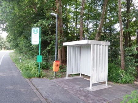 Fahrgäste warten jetzt regengeschützt und beleuchtet. Keine Beleuchtung und ein undichter Unterstand: Der Fahrgastunterstand an der Bushaltestelle Marienfelder Straße/Holzheide war bis vor einigen Wochen in einem schlechten Zustand. Das ist nun anders. Um den Zeitraum bis zur ohnehin fest eingeplanten Komplett-Erneuerung zu überbrücken, hat die Stadt Gütersloh kurzerhand ein (wiederverwendbares) Provisorium errichtet – einen neuen Unterstand samt Straßenlaterne. Jetzt warten Fahrgäste regengeschützt und gut sichtbar. Der Hintergrund: Die Haltestelle Marienfelder Straße/Holzheide ist Bestandteil des seit 2015 laufenden Ausbauprogramms der Stadt Gütersloh. Es sieht vor, bis zum Jahresende 2023 zirka 285 Bushaltestellen barrierefrei auszubauen. Bis Ende 2020 werden voraussichtlich rund 155 und damit mehr als die Hälfte fertiggestellt sein. Weil die Haltestelle Marienfelder Straße/Holzheide an einer Bundesstraße liegt, greift hier die Besonderheit, dass der Landesbetrieb Straßen NRW als Baulastträger der Straße zwingend eingebunden werden muss und die Planungen in Abstimmung erstellt werden müssen. Denn an übergeordneten Straßen gelten zum Teil höhere Anforderungen an die bauliche Ausformung von Haltestellen. Das Verfahren läuft bereits. Geplant ist die Erneuerung der Haltestelle für 2022/2023. Um den Zeitraum bis dahin zu überbrücken und die Wartesituation kurzfristig deutlich zu verbessern, hat die Stadt Gütersloh als Zwischenlösung den provisorischen Unterstand und die Laterne errichtet. Beides kann später wieder abgebaut und an anderer Stelle erneut verwendet werden.
