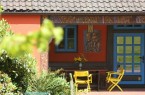 Bunte Idylle im Grünen: Das Böckstiegelhaus besticht durch rote Fassade mit blauen Fensterläden, Copyright: © Peter-August-Böckstiegel-Stiftung