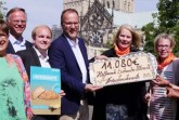 Bei der Übergabe des Spendenchecks aus Marzipan: v.l. Anne Hakenes, Vorsitzende des Trägervereins, Domkapitular Klaus Winterkamp, Michael König, Hama Backservice, Georg Krimphove von der Bäckerei Krimphove, Barbara Brinkmann und Hildegard Micheel-Meier,sowie  Schwester Lea Rose vom Orden "Dienerinnen der Armen" (Foto: katholikentag.de / Katzenberger)