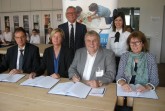 Unterzeichneten den Kooperationsvertrag: Swen Binner, Claudia Holtkemper, Andreas Stork, Regina Meißner-Schlömer (von links sitzend) mit Wilhelm Wolters, Leiter technische Ausbildung, und Silvia Lobert, stellvertretende Fachbereichstleitung Bürgerdienste (von links stehend).