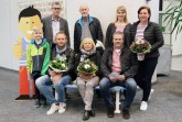 Die Gewinner der Baumesse haben auf der Stadtwerk-Bank Platz genommen (v.l.) – Mats mit Vater Dietmar Boeckh, Anne Köhler und Kai Hoffmann. Oben freuen sich (v.l.) Geschäftsführer Torsten Fischer, Heinz Köhler, Kundenberaterin Stephanie Heber und Heike Hoffmann mit. © Stadtwerk Rheda-Wiedenbrück
