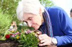 Eine Nase Blumenduft: Ingeborg Meyer genießt das Angebot Gartengruppe mit allen Sinnen.Foto: Johanneswerk / Christian Weische