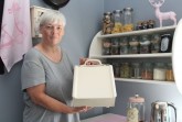 : Gemütlich: Ein Korbsessel vom Flohmarkt ergänzt die Einrichtung: Marion Grages vom Fachbereich Umweltschutz beim „Upcycling-Rundgang“ durch das Haus mit Patricia Sommermann.