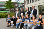 Symbolische Übergabe der ersten Exemplare des  IHK-Ausbildungsatlanten 2019 an das Max-Planck-Gymnasium Bielefeld (MPG): Oliver Rouvray, Studien- und Berufswahlkoordinator des MPG, MPG-Schulleiterin Andrea Kleist, IHK-Hauptgeschäftsführer Thomas Niehoff sowie IHK-Geschäftsführer Swen Binner (stehend v. l.) mit den angehenden MPG-Abiturienten Erik Gajowski, Jonas Simon Lahr, Sema Demir, Wiebke Meyer, Lea Malin Mößinger, Alina Kuka und Neele Winkler (kniend v. l.). Foto: IHK