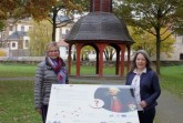 Monika Finke, Behindertenbeauftragte der Stadt Büren, und Kerstin Salerno, Stadtmarke- ting Büren, geben das Muster für die neuen barrierefreien Informationstafeln im Bürgerpark zur allgemeinen Ansicht frei.
