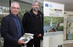 Umweltabteilungsleiter Lutz Kunz von der Bezirksregierung Detmold (links) und Peter Rüther, Leiter der Biologischen Station Kreis Paderborn, eröffnen die Ausstellung zum LIFE-Projekt „EggeMoore – Biologische Vielfalt im südlichen Eggegebirge“ im Foyer der Bezirksregierung in Detmold.