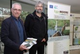 Umweltabteilungsleiter Lutz Kunz von der Bezirksregierung Detmold (links) und Peter Rüther, Leiter der Biologischen Station Kreis Paderborn, eröffnen die Ausstellung zum LIFE-Projekt „EggeMoore – Biologische Vielfalt im südlichen Eggegebirge“ im Foyer der Bezirksregierung in Detmold.