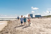 Barfuß im Sand: Am Warnemünder Strand können Kinder sich austoben. Foto: TMV/Süß