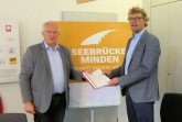 Übergabe: Pfarrer Bernhard Speller (Evangelischer Kirchenkreis Minden, links) übergab knapp 1000 Unterschriften für die „Seebrücke Minden“ an Bürgermeister Michael Jäcke.Foto;(© Pressestelle der Stadt Minden