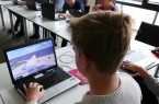 Junge spielt das Videospiel Minecraft an einem Laptop