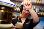Junge Frau zapft Bier vom Fass
