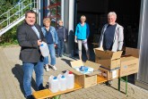 Landrat Dr. Axel Lehmann macht sich ein Bild von der Verteilung der Schutzmaterialien: Anke Stetza, Ute Model und Anja Krause (von links) von der Pflege- und Heimaufsicht haben zahlreiche Kisten gepackt. Karl-Heinz Bredenkamp holt das Material für den Lippischen Blinden- und Sehbehinderten-Verein ab. Foto: Kreis Lippe