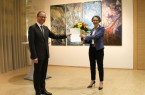 Ministerin Ina Scharrenbach überreicht die Ernennungsurkunde und einen Blumenstrauß an Jörg Düning-Gast, im Hintergrund Werke der ostwestfälischen Künstlerin Rosemarie Sprute.
