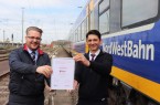Eduard Skura (rechts) bekommt die Auszeichnung für den Landessieg von Robert Palm, Regionalleiter der Regio-S-Bahn Bremen/Niedersachsen überreicht. Foto: NordWestBahn/Steffen Högemann