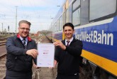 Eduard Skura (rechts) bekommt die Auszeichnung für den Landessieg von Robert Palm, Regionalleiter der Regio-S-Bahn Bremen/Niedersachsen überreicht. Foto: NordWestBahn/Steffen Högemann