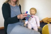 Mit Puppe und Laptop: PEKiP Kursleiterin Dagmar Lamprecht bei Ihrem Online-Kurs „PEKiP Digital“. Foto: