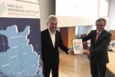 Prof. Dr. Andreas Pinkwart (links) lobte bei seinem Besuch in Paderborn die Arbeit in der digitalen Modellregion OWL und nahm die Absichtserklärung von Bürgermeister Michael Dreier (rechts) entgegen. Foto: © Stadt Paderborn