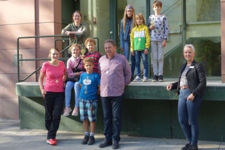 Franziska Huhnke (l.), Team Jugend- und Erwachsenenbibliothek, und Anja Krokowski (r.), stellv. Bibliotheksleiterin, freuen sich mit Familie Beil und Familie Homuth, die stellvertretend für alle diesjährigen Sommerleseclub-Gewinner zum Fototermin kamen (v. l.).Foto: Stadt Gütersloh