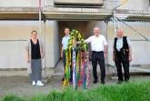 Bürgermeister Ernst-Wilhelm Vortmeyer, Schulleiterin Maren Erntner, Zimmerermeister Gerd Kienker und Architekt Stefan Bäunker mit der Richtkrone, die von den Grundschulkindern geschmückt wurde.Foto: Gemeinde Rödinghausen