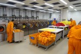 Hochleistungs-Wäscherei: Auch die Mitarbeiter, die hier tätig sind, tragen Schutzanzüge – wie alle im Kontrollbereich von Block C im Kernkraftwerk Gundremmingen. Mit Miele-Technik wird die komplette Berufskleidung hygienisch aufbereitet. (Foto: Kernkraftwerk Gundremmingen GmbH)