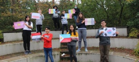 Die Kinder präsentieren stolz die selbstgemalten Flaggen ihrer Heimatländer.Foto: Kreis Gütersloh