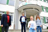 Sportdezernent Wolfgang Walter (links aussen) gratulierte Claudia Lingnau (vorne im Bild) persönlich zu ihrem Siegerentwurf für die Medaille zur Sportlerehrung der Stadt Paderborn im Beisein von Siegfried Rojahn, Schulleiter des Reismann-Gymnasiums (hinten) und Kunstlehrerin Inés Schuh (rechts aussen).Foto: © Stadt Paderborn