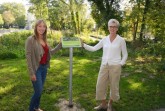 Die Technische Beigeordnete Claudia Warnecke (rechts) freut sich zusammen mit der Landschaftsökologin Lea Heinrichsdorff (Amt für Umweltschutz und Grünflächen der Stadt Paderborn) über die positive ökologische Entwicklung an der renaturierten Pader und ihren Quellen. Zum Schutz der dort lebenden Pflanzen- und Tierarten haben sie Hinweisschilder aufstellen lassen. Foto: © Stadt Paderborn