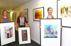Künstler-Poster: (v.l.) Lena Jeckel, Karin Hauertmann und Amy Kohaus vom Fachbereich Kultur vor und mit einigen der 25 Reproduktionen, die als Dauerausstellung in der Stadthalle hängen und im Internet auf dem Kulturportal Gütersloh in einer Online-Kunstgalerie zu sehen sind. Mit der Aktion, Poster von Kunstwerken anzufertigen und diese den Gütersloher Kunstschaffenden für die Eigenwerbung und den Verkauf zur Verfügung zu stellen, unterstützt der Fachbereich Kultur heimische Kulturakteure.Foto: Stadt Gütersloh