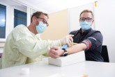 Thorsten Engelking, Mitarbeiter des HDZ NRW (Foto li.), nimmt EDEKA-Mitarbeiter Mario Grotefeld Blut ab für den Antikörpertest.  Foto: 	EDEKA Minden-Hannover