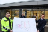 Bernhard Riepe, Krisenstabsleiter Frank Scheffer und Henrik Egeler präsentieren vor dem Eingang den Plan für das Impfzentrum. Foto: Kreis Gütersloh