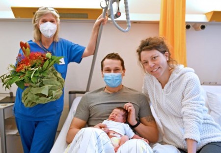 Heike Meinefeld, leitende Hebamme im EvKB und die glückliche junge Familie.