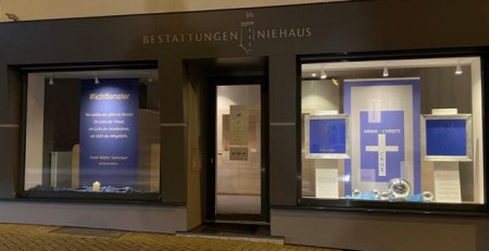 Das Licht in den Schaufenstern von Niehaus Bestattungen betont, wie wichtig jeder einzelne Corona-Verstorbene ist. Foto: Andreas Niehaus