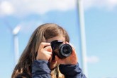 Eine junge Fotografin bei der Motivsuche. Alle Bürgerinnen und Bürger sind eingeladen, Bilder zum Thema „Erneuerbare Energien“ an den Kreis Höxter zu senden. Foto: Klimakampagne OWL