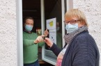 Der Leiter des Treffpunkts Johanniskirchhof, Georg Sander, übergibt einen Schlüsselanhänger an eine Bürgerin.Foto © Stadt Minden