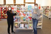 Jennifer Bader (links) und Julia Bröckling vom Team der Stadtbibliothek können es kaum abwarten, das Regal mit neuen Büchern ausschließlich für Sommer-Lese-Club-Mitglieder freizugeben. Foto: Stadt Rietberg