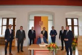 Karl Josef Laumann (vorne), Minister für Arbeit, Gesundheit und Soziales des Landes NRW, trägt sich im Beisein von (v. l.) Aloys Buschkühl (Geschäftsführer der Kreishandwerkerschaft Paderborn-Lippe), Michael H. Lutter (Hauptgeschäftsführer der Kreishandwerkerschaft Paderborn-Lippe), Mickel Biere (Kreishandwerksmeister), Bürgermeister Michael Dreier, Dr. Carsten Linnemann (Mitglied des Bundestags), Michael Friemuth (Stv. Kreishandwerksmeister) und Daniel Sieveke (Mitglied des Landtags) in das Goldene Buch ein.Foto: © Stadt Paderborn