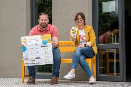 Heiko Böddeker und Julia Handtke (beide GfW Höxter) mit dem neuen Heimatlotsen auf der gelben Bank, dem Markenzeichen der Rückkehr Agentur. Foto: ©Irina Jansen