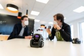 Adrian Freiter (links) und Roman Sliwinski besprechen die nächsten Planungsschritte ihres Projekts, im Vordergrund sieht man einen der Vector-Roboter. (Foto: Felix Hüffelmann / FH Bielefeld)