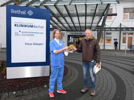 Ulrike Graulich nimmt gerne die Gutscheine entgegen, die Matthias Jaene und seine Kollegen vom Kundenservice der Deutschen Post für das Pflegeteam der Intensivstation gespendet haben. Foto: EvKB 