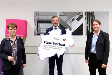 Staatssekretär Dr. Dirk Günnewig überreichte Prof. Dr. Christa Büker (links) und Prof. Dr. Änne-Dörte Latteck (rechts) den Förderbescheid über 500.000 Euro für das Projekt "KomVor", in dem digitales Lehr-Lernmaterial für Pflegestudierende entsteht. (Foto: L.Kruse/FH Bielefeld)