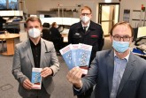 Landrat Michael Stickeln (l.) und Matthias Kämpfer (r.), Leiter des Fachbereichs Öffentliche Sicherheit und Straßenverkehr, zeigen den neuen Flyer, mit dem der Kreis Höxter über das Warnsystem informiert. Bei einer drohenden Gefahrenlage kann von der Leitstelle des Kreises Höxter in Brakel die Warnung der Bevölkerung gesteuert werden. Mit seinem Team koordiniert Leitstellenleiter Jürgen Romund die Auslösung der über 160 Sirenen im Kreis, ebenso wie Alarmierungen über die Warn-App NINA. Foto: Kreis Höxter.