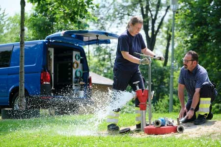 Die Wasserexperten Nadine Harz und Siegmund Buschke entnehmen Wasser an einem Hydranten. Foto: Thorsten Ulonska