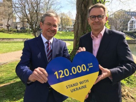 Zeichen der Solidarität: Bernd Schäfers-Maiwald vom Paderborner Unternehmen dSpace übergibt den symbolischen Scheck in Herzform an Bürgermeister Michael Dreier.Foto:© Stadt Paderborn 