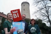 Jill Mallin, Martin Knabenreich und Gabriela Lamm von Bielefeld Marketing (v. l.) stellen die touristischen Angebote zum Saisonstart vor. Unter anderem gibt es ein neues Angebot im Verlies direkt unter dem Burgturm: ein unterhaltsames Weinquiz. Bildnachweis: Bielefeld Marketing GmbH
