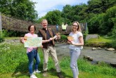: Stellen die neue Erlebniskarte für die Almeauen vor: Isabel Schulte (Stadtmarketing), Matthias Rickling (Redakteur) und Anke Hammerström (stellv. Leitung Stadtmarketing) sowie auf der Brücke: Jasper, Annelie und Flora. Foto: Stadt Büren